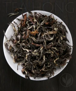 The beautiful small leaves of Oriental Beauty, spotted with tiny furry pekoe young leaf shoots and deeply oxidised red colour young leaves