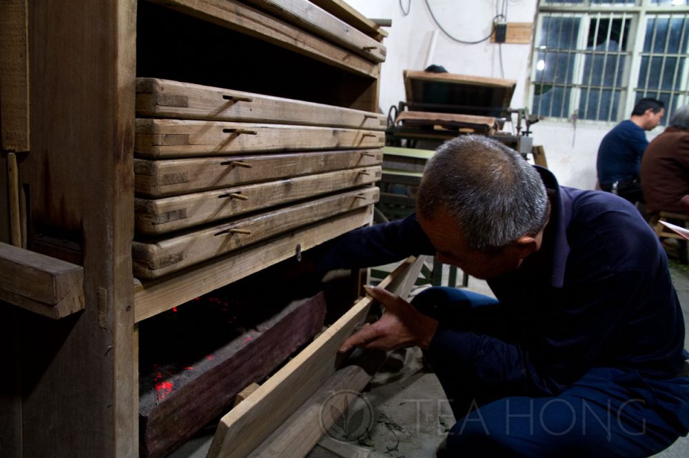 Master Wang reaching into the charcoal tray