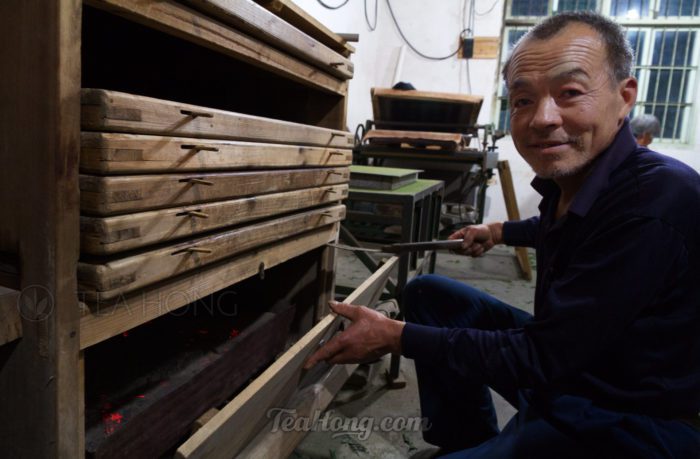 The tea producer turning coal at the tea baking oven