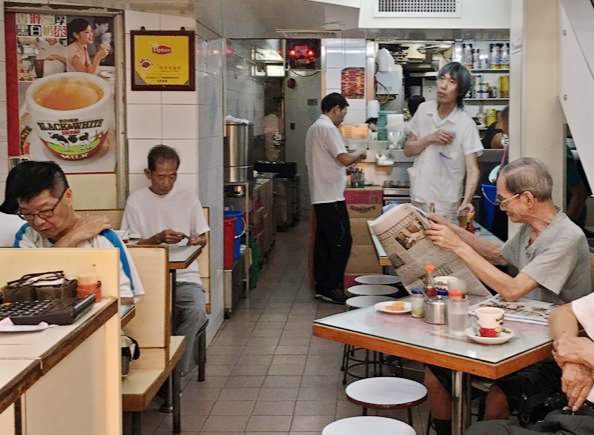 Inside of a HK style neighbourhood diner with a poster of HK style milk tea on the wall