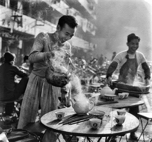 A man pouring steaming hot water into a teapot in a dai pan dong (open air eatery) in Shek Kip Mei in Hong Kong, 1960's