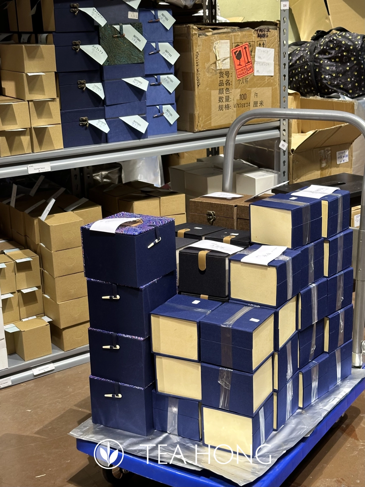 Boxes of teapots on the stock shelves and on a trolley