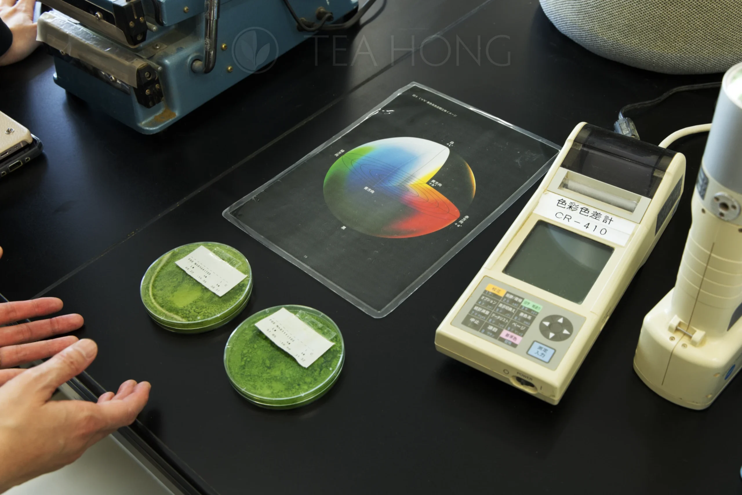 A chromatic value reader with two dishes of matcha and a chromatic chart