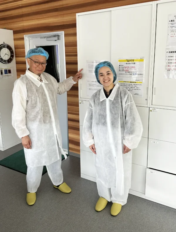 Olivia and myself dressed in surgical overalls and designated slippers at the door of a facility