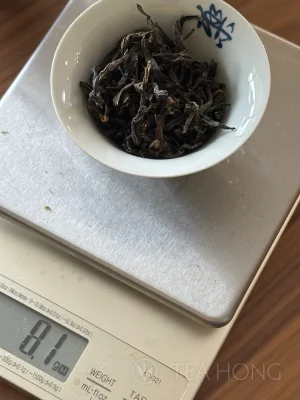 Tealeaves filling a small gaiwan on a scale, the reading: 8.1g
