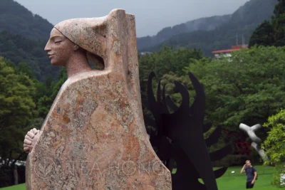 Tall human figure red marble sculpture of a pilgrim