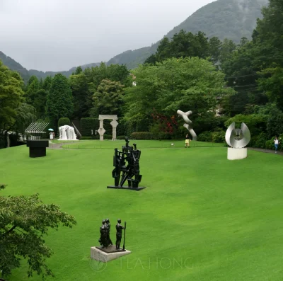 Seven pieces of sculptures on a lawn each of a different style