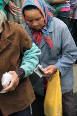 An old lady checking the few banknotes she got from selling this round of jasmine picks