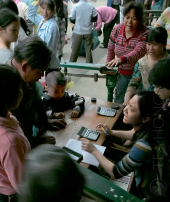 The buyer of a collection counter arguing with a picker on the amount to be paid, with a crowd around