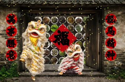 Two cute Cantonese style lion dance lions, one red, one yellow, in front of a traditional style rural home with the door wide open, showing a large varieties of tea in rows and columns in same size white dishes. A Lunar New Year well wishing couplet on each side of the door and a big 45° tilted square one in the middle of the door way with the large character 福, meaning blessings, in the centre.