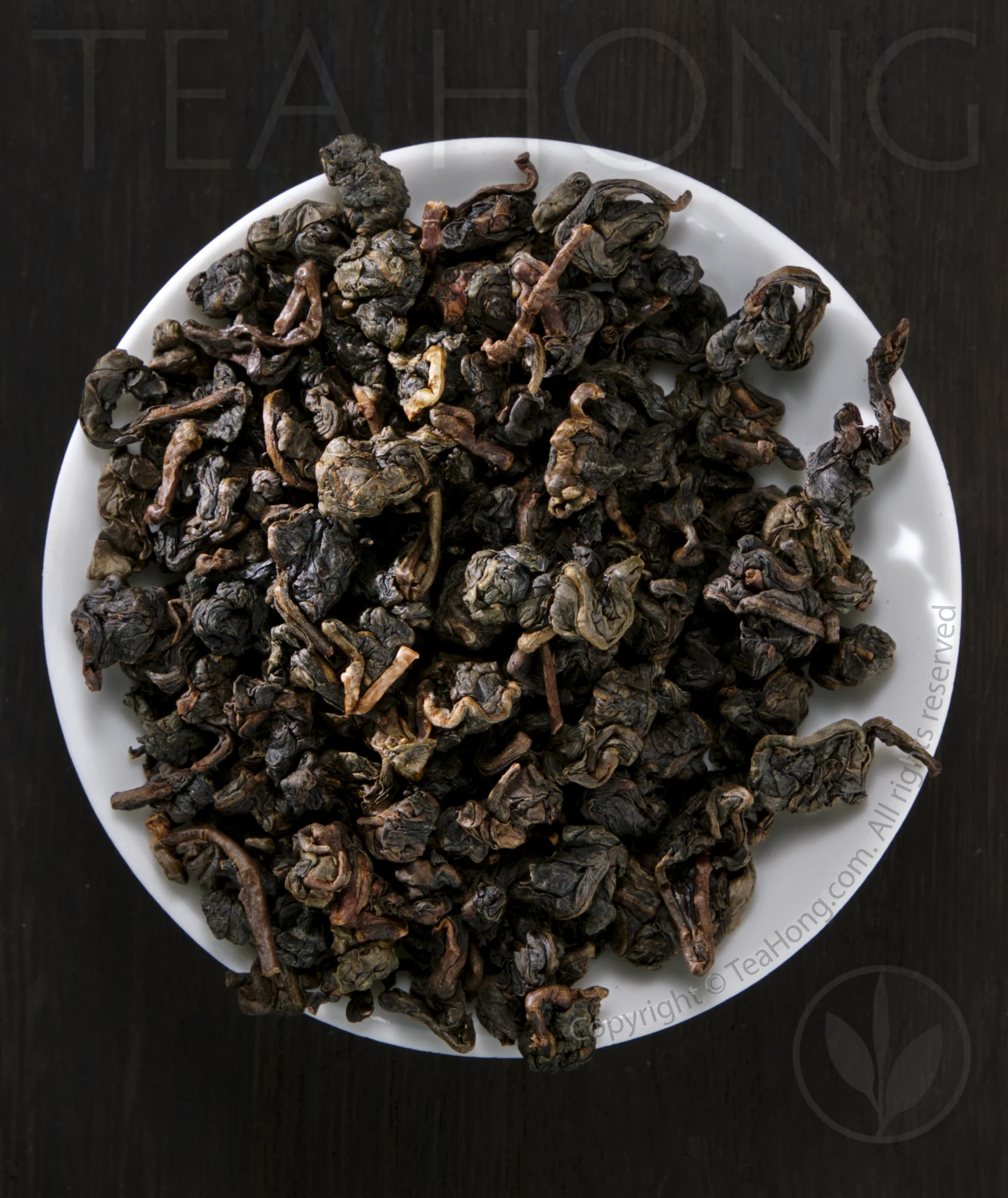 muzha tieguanyin re Bead shaped tealeaves with deep colours on a small white dish