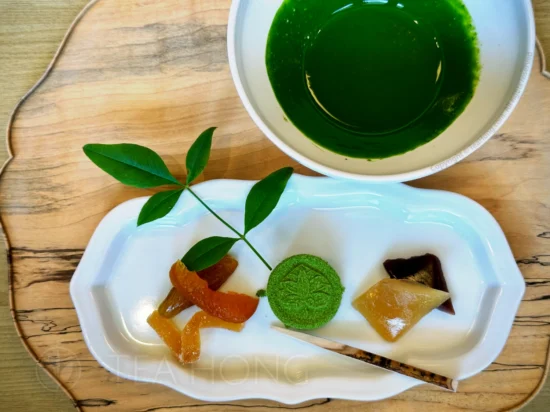 Nishio Matcha Koicha afternoon tea set A chawan with an intensely dark green colour matcha prepared in the koicha style, next to an oblong shape dish laid with Japanese traditional desserts, wakoshi