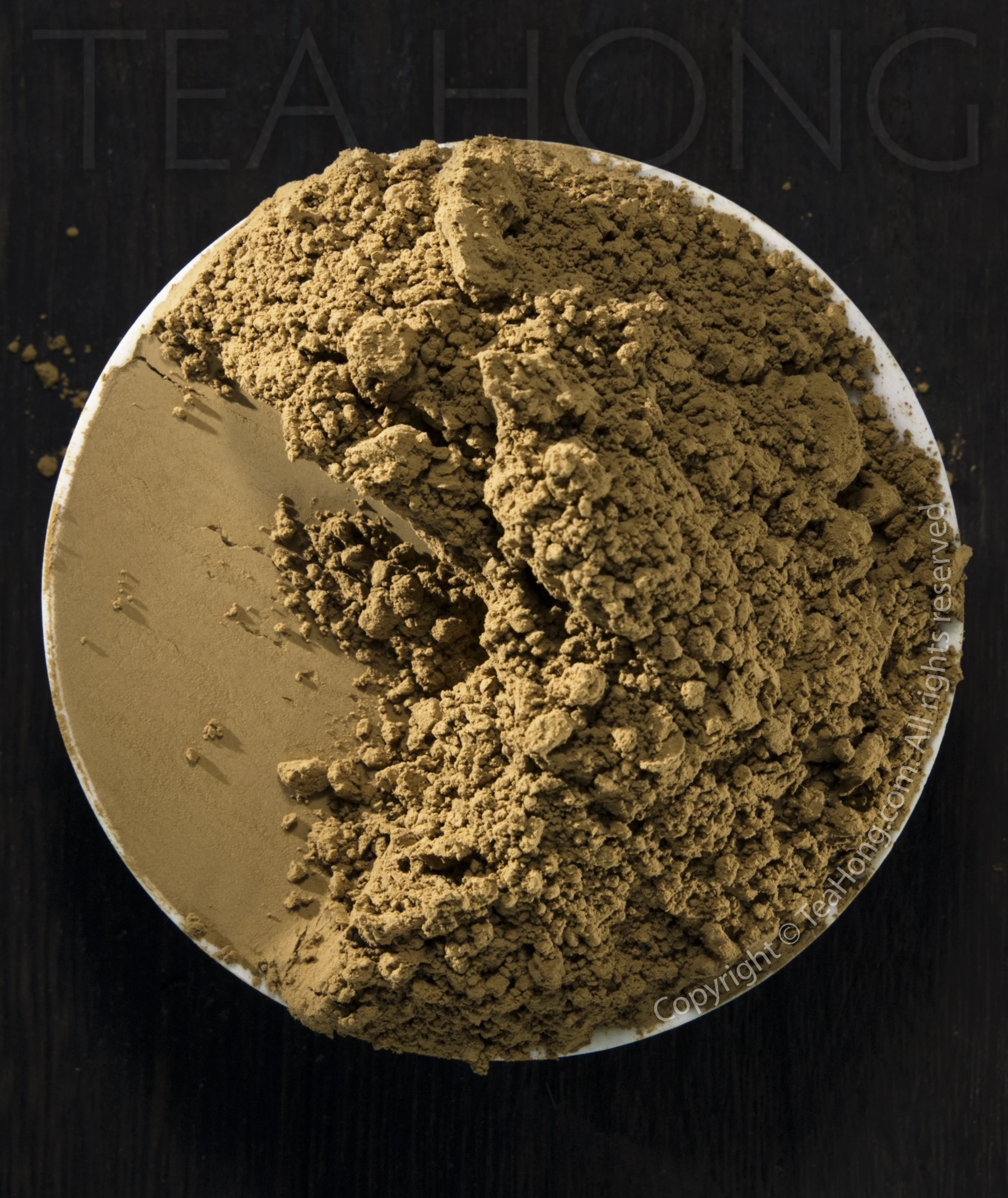 Kyoto Houjicha Powder A small white dish filled with a fine powder that is rich brown in colour. A quarter of the dish is scraped to reveal how smoothly fine the powder is when pressed