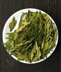 Longjing Traditional Supreme The roasted leaves of the green tea Longjing Traditional Supreme on a small white dish