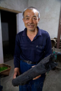"This charcoal is very different from what you can buy from the shop," said Master Wang. "I made all the charcoal myself from trees around here that I know can yield a good smell when burning." He posted for me after walking me to the charcoal making hut, showing off his charcoal pile. It was too dark outside already, so we went back to his workshop to picture this. An old man holding a perfect looking log of wood charcoal