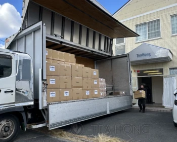 Worker loading a truck for one of our export orders at the entrance of our current operation site in Nagoya, Japan. Worker moving a Tea Hong export carton onto a truck, which is already loaded with similar cartons
