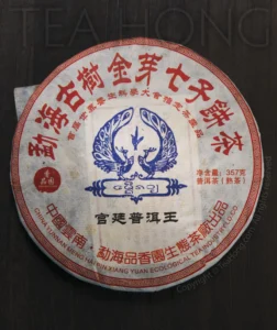 Front side of the wrapping paper. The title reads: Menghai (the county that holds the Xishuangbanna area) Old Tree Golden Flush Qizibing cha (7 pieces cha bing cha — an old name referring to the traditional bing cha packaging standard of wrapping 7 cha bing in a bamboo casing) Front side of the wrapping paper